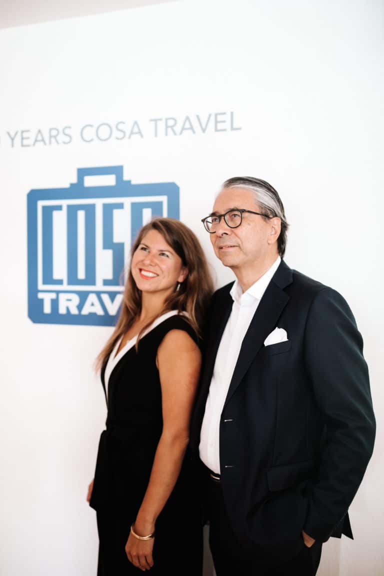 George and Nina Mueller standing next to each other with the Cosa logo in the back