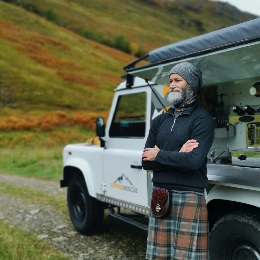 Man proudly wears a kilt that emphasizes the timeless tradition and rugged beauty of the region.