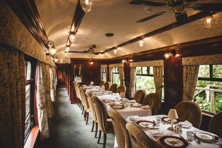 An elegant dining setup inside a train car with ambient lighting.