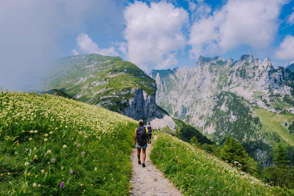 A woman with a backpack hiking at Saxer Lucke, Kreuzberg in Alpstein Appenzell Innerrhoden Switzerland.