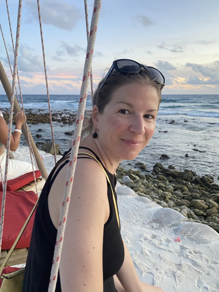 Korine Weideli sits by the sea and smiles