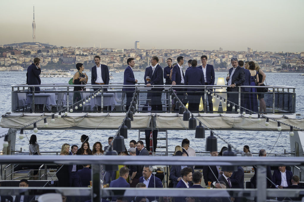 A group of people in suits enjoy an aperitif during a corporate event in Istanbul, Turkey.