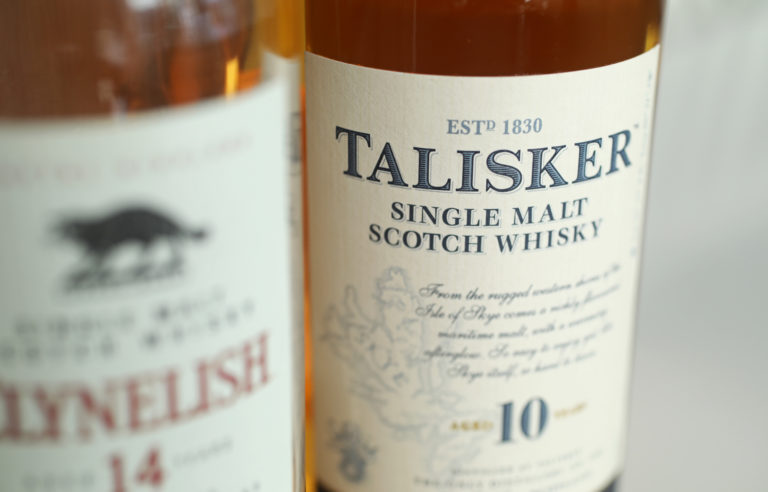 Closeup of the Talisker logo on a single malt Scotch whisky bottle inside a cozy setting.