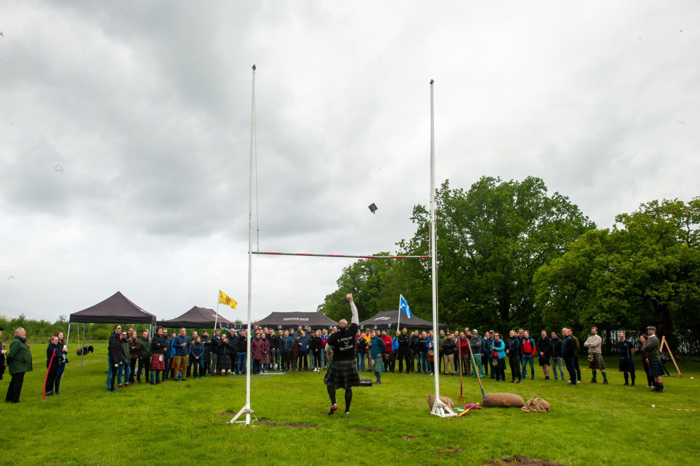 A man shows his strength by throwing a weight at an event in Scotland.