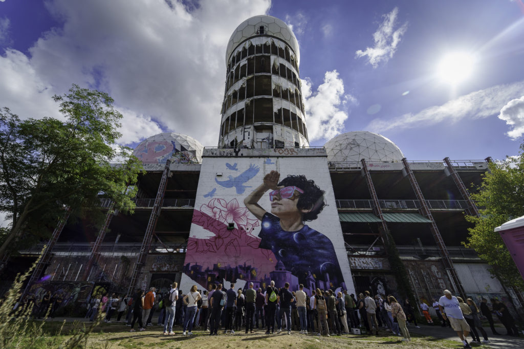 A group of people stand in front of a cool location with lots of graffiti during an event in Berlin.