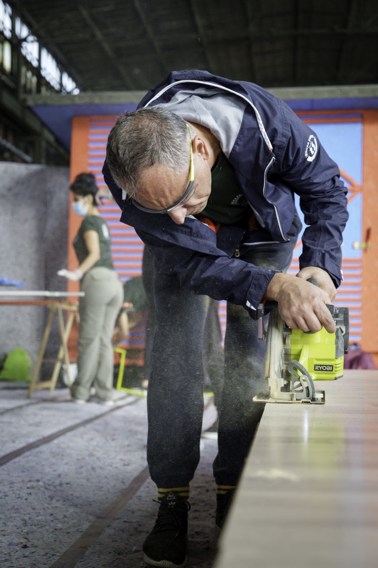 A man cuts wood during a CSR day at an event in Berlin.