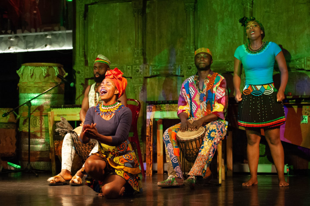 A group of musicians dance and sing on stage in Cape Town.