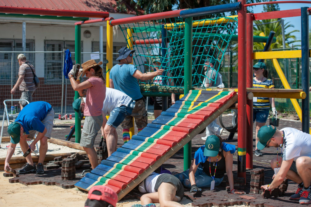 A group of people are building a playground for children in a township in Cape Town.