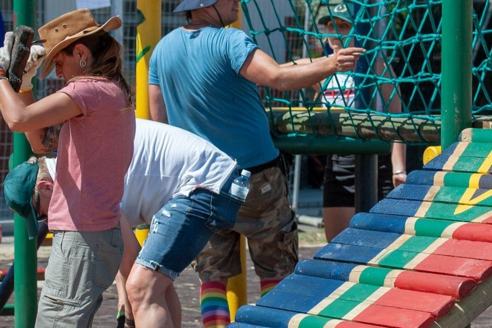 A group of people build a playground for children in a township in South Africa during a CSR project.