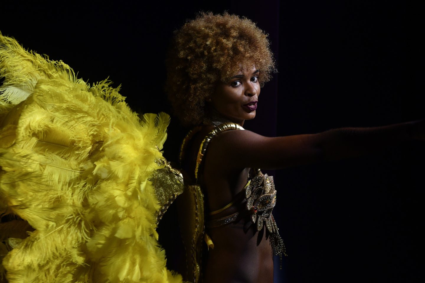 A dancer with feathers adorns guests at an event in Cape Verde.