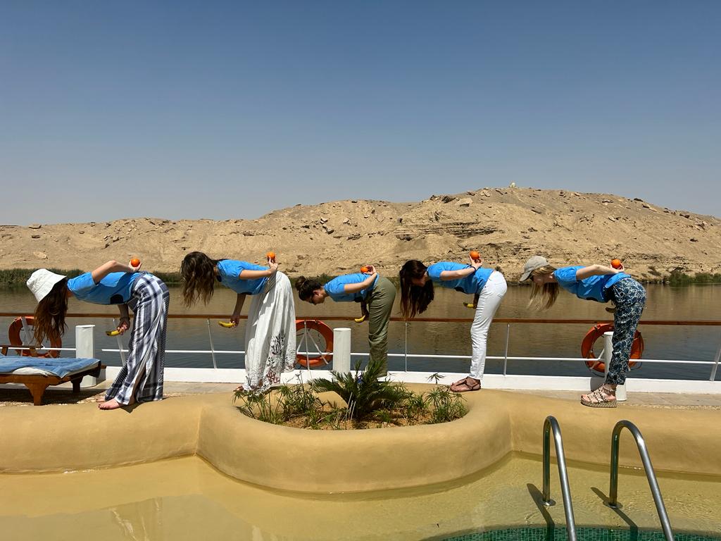 A group of people recreate an Egyptian mural painting.