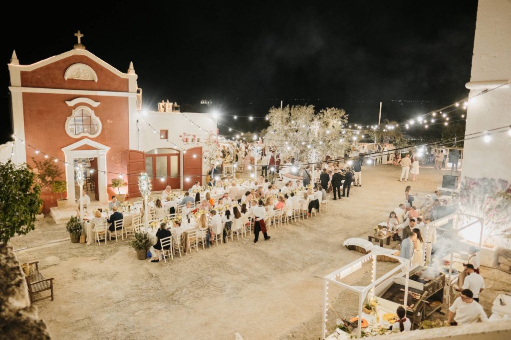 A lively evening takes place on a beautifully decorated piazetta during a private event in Puglia.