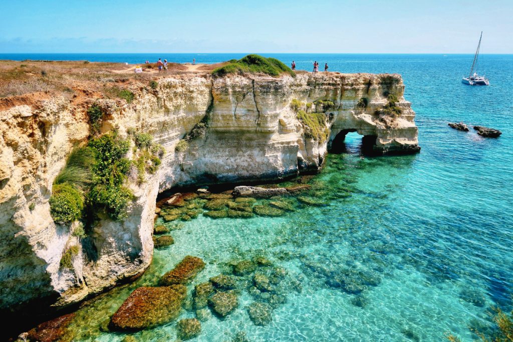The crystal-clear turquoise water in Puglia, Italy invites visitors to take a dip.